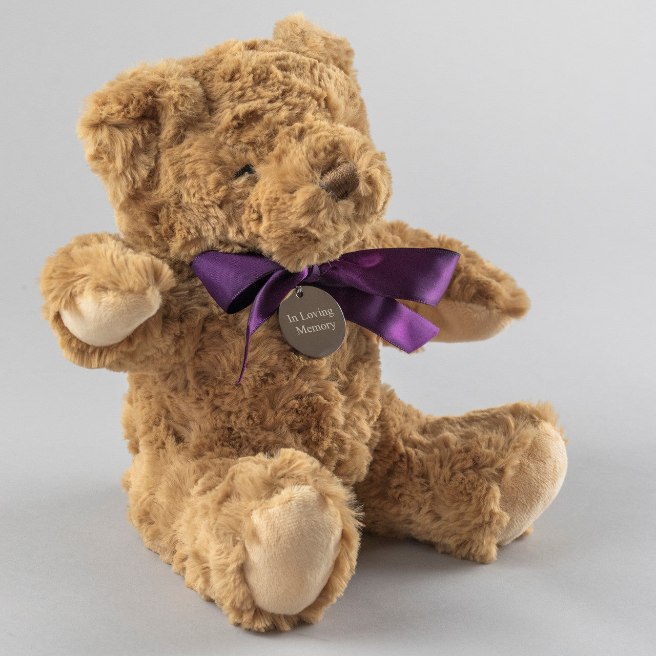 Supersoft brown bereavement  teddy bear wears a purple ribbon and an engraved tag with the words In Loving Memory. Tag can be engraved with your own message.