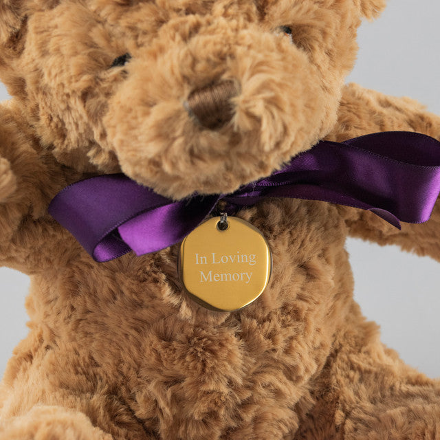 Supersoft brown bereavement teddy bear wears a purple ribbon and an engraved tag with the words In Loving Memory. Tag can be engraved with your own message.