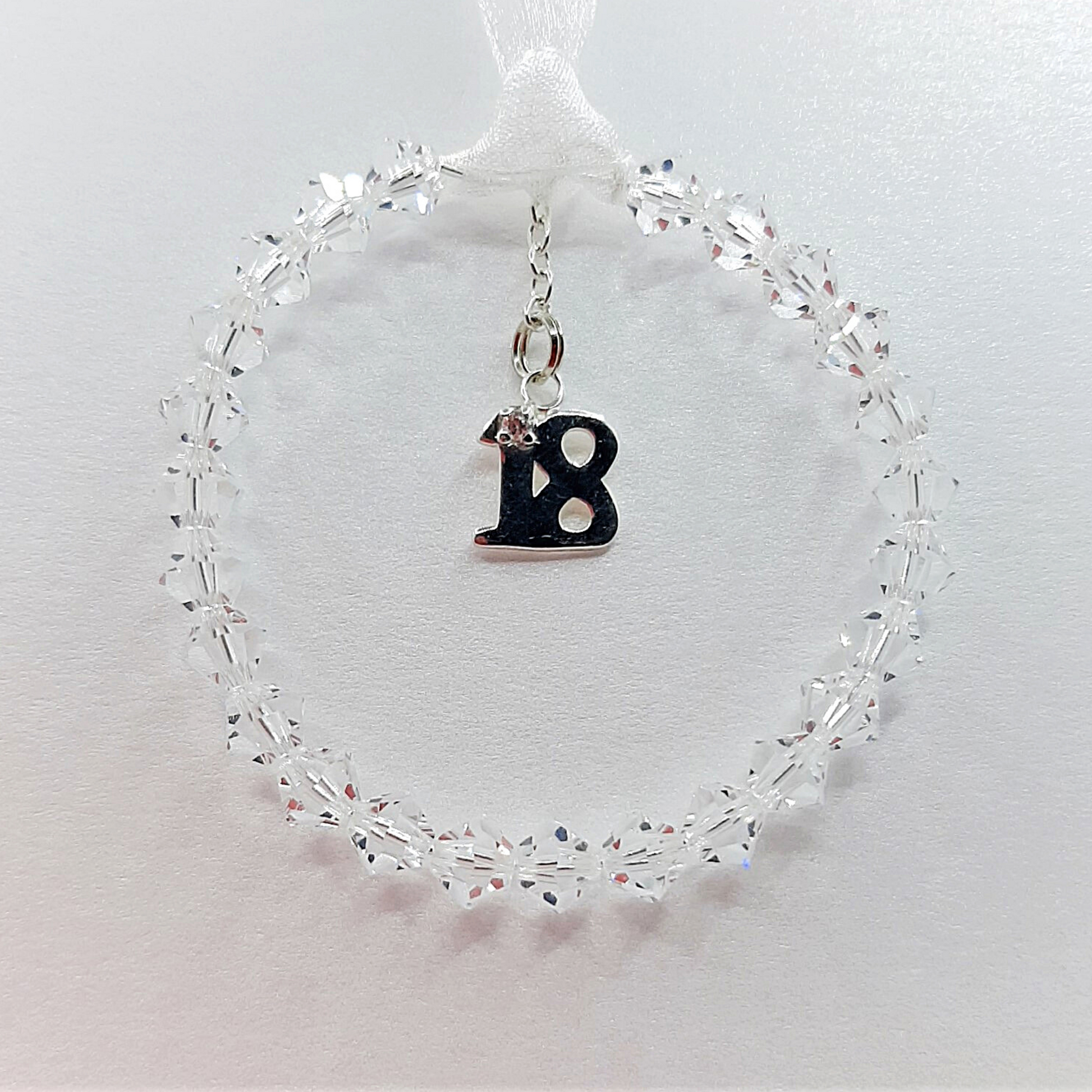18th birthday hanger, crystal circle with sterling silver 18 which includes diamante, hanging from white ribbon
