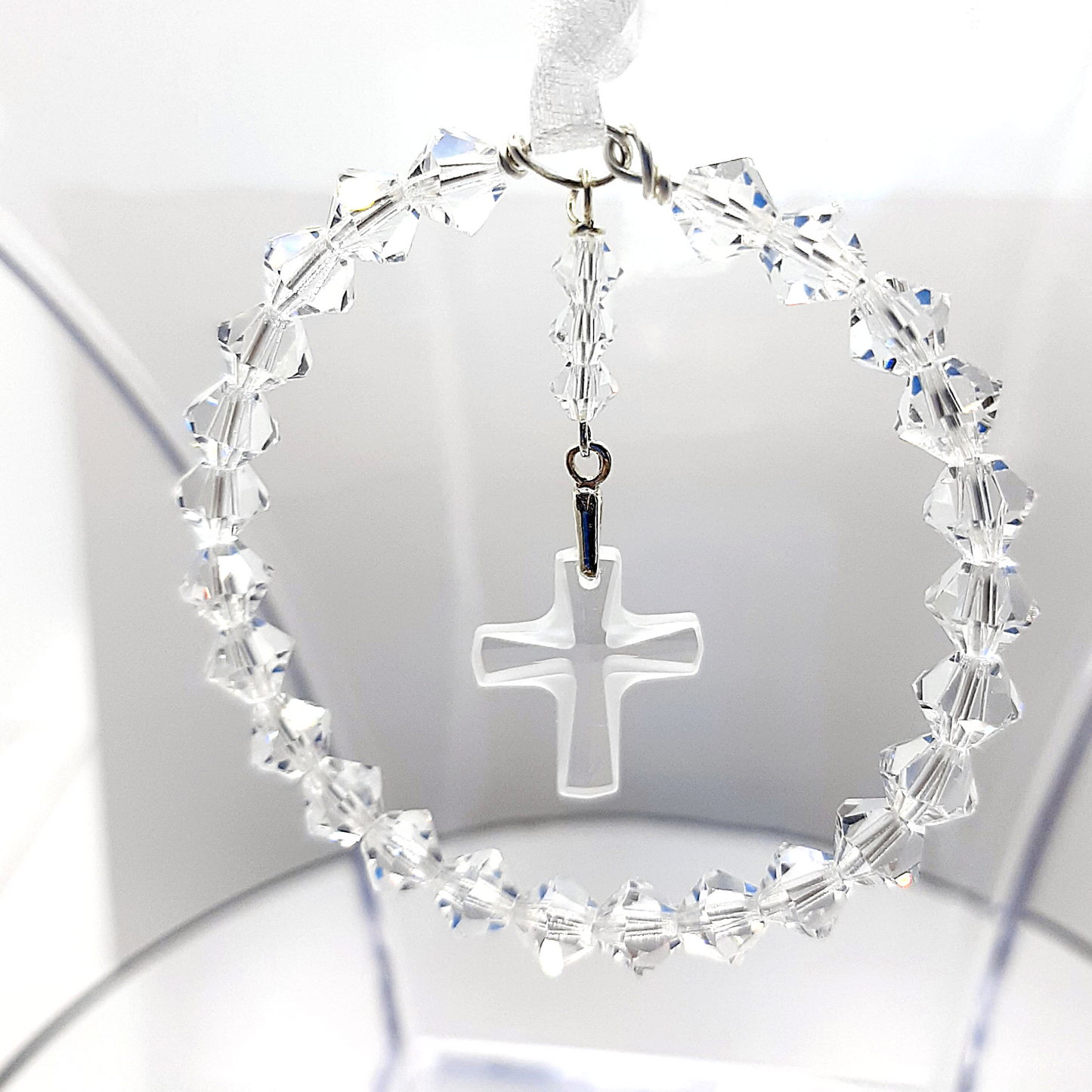 A circle of high grade austrian crystals surrounds a crystal cross suspended from the centre of the circle. Sparkling crystal ribbon completes the charm ready to hang on a gift card of your choice.