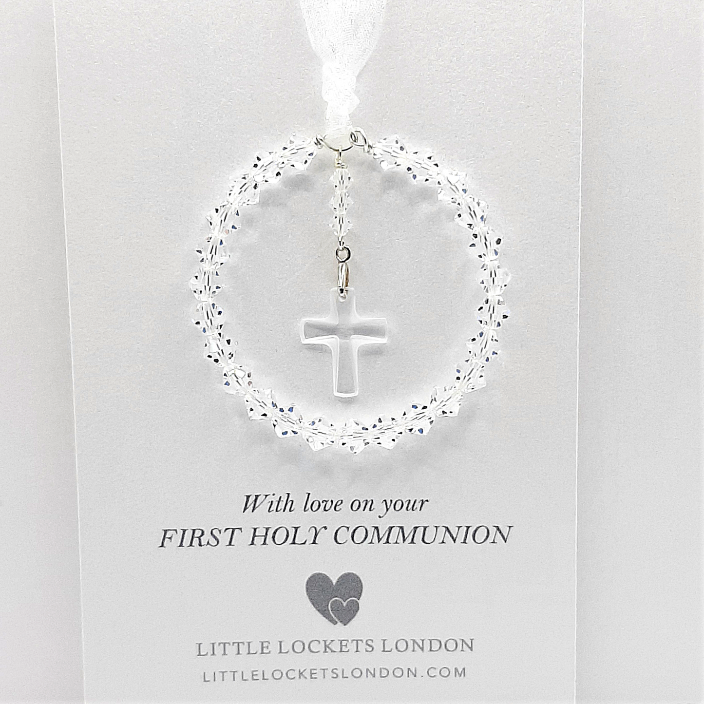 A circle of high grade austrian crystals surrounds a crystal cross suspended from the centre of the circle. Sparkling crystal ribbon completes the charm. Shown on gift card printed with your personal message