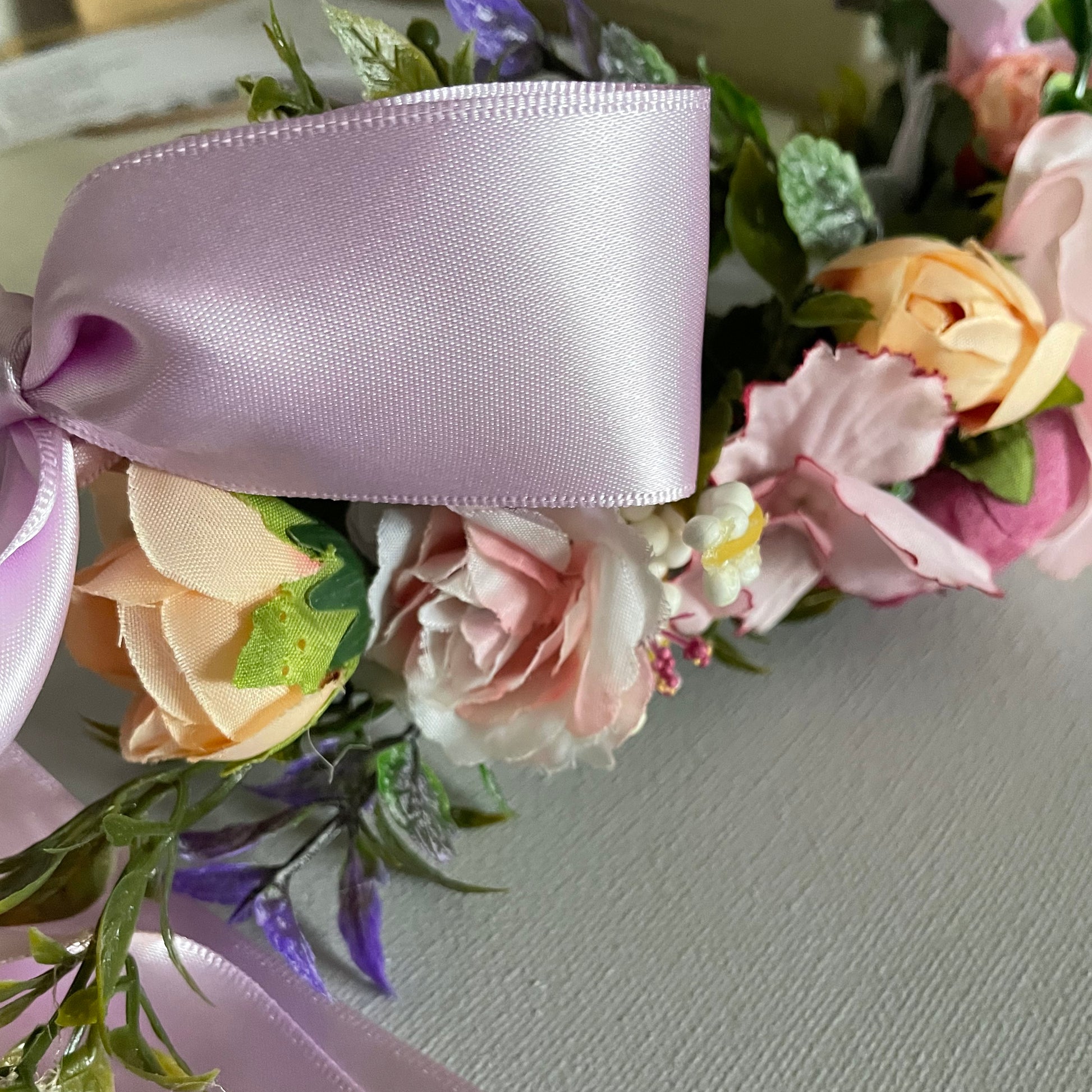 Close view of flowers and ribbon on dog flower collar in pinks purples blush and hints of green