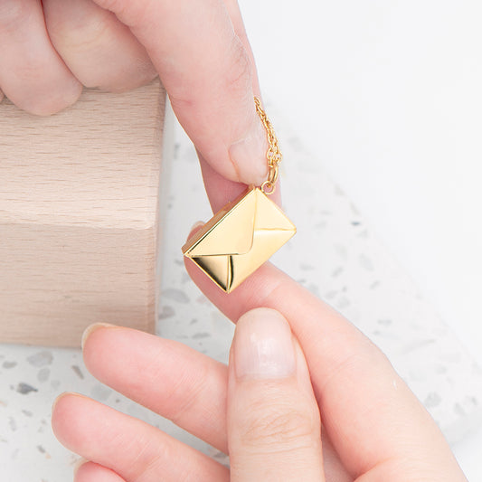 Tiny gold plated envelope hung from a gold plated chain