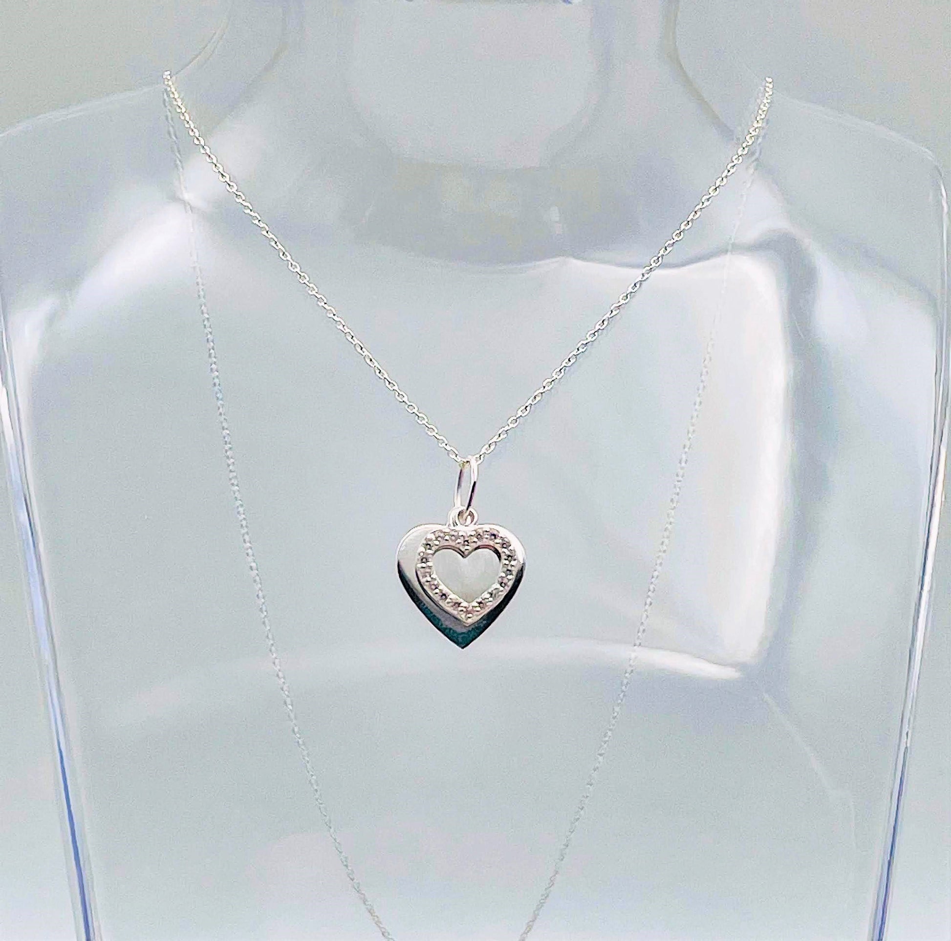 A sterling silver solid heart sits behind an outline heart with cubic zircona and suspended from a sterling silver chain. Your necklace arrives in a small glass bottle with a scroll for you to add your own message. 