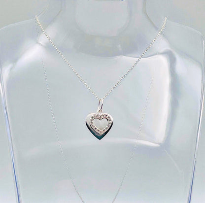 A sterling silver solid heart sits behind an outline heart with cubic zircona and suspended from a sterling silver chain. Your necklace arrives in a small glass bottle with a scroll for you to add your own message. 