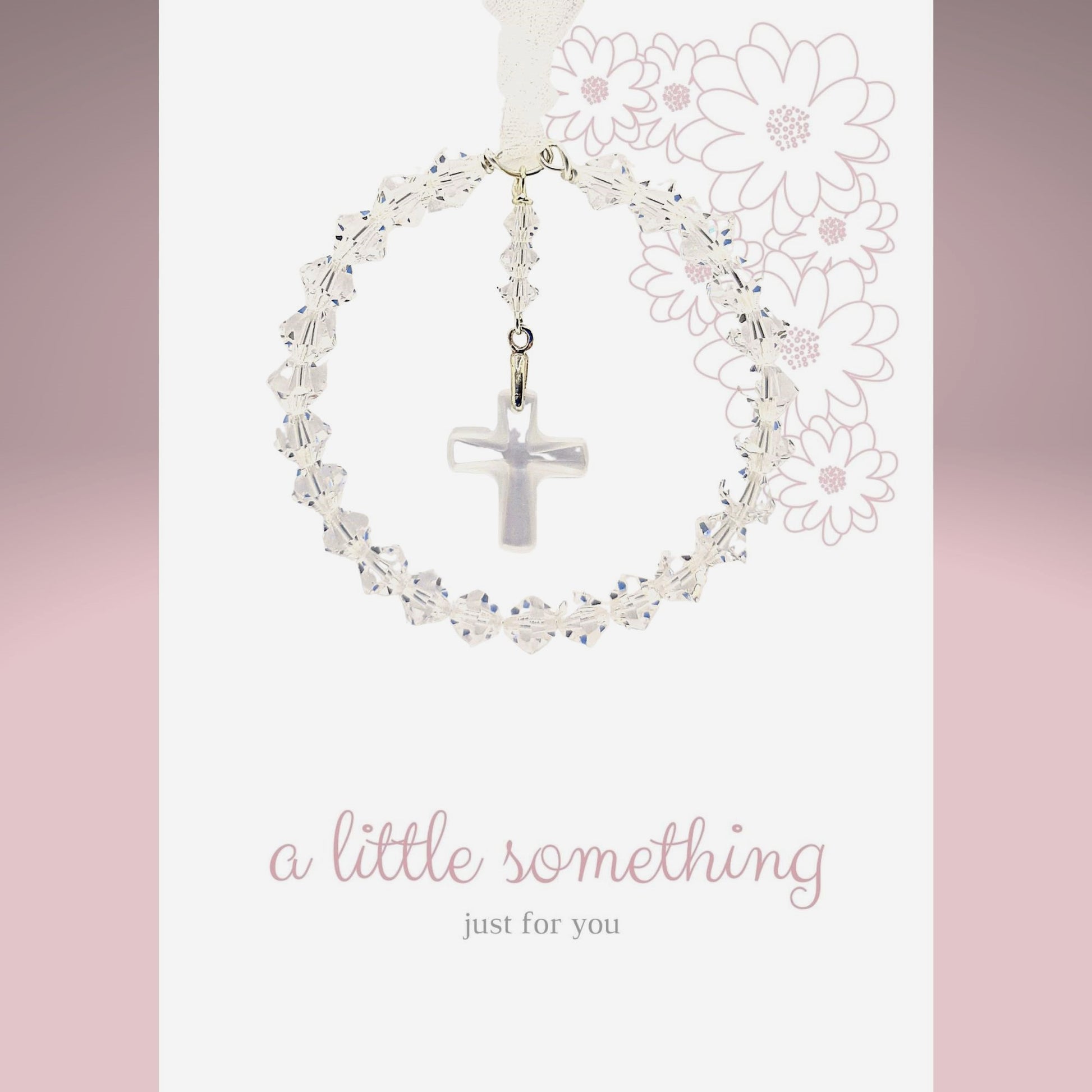 A circle of high grade austrian crystals surrounds a crystal cross suspended from the centre of the circle. Sparkling crystal ribbon completes the charm. Shown on a pre-printed card with the message "a little something just for you"