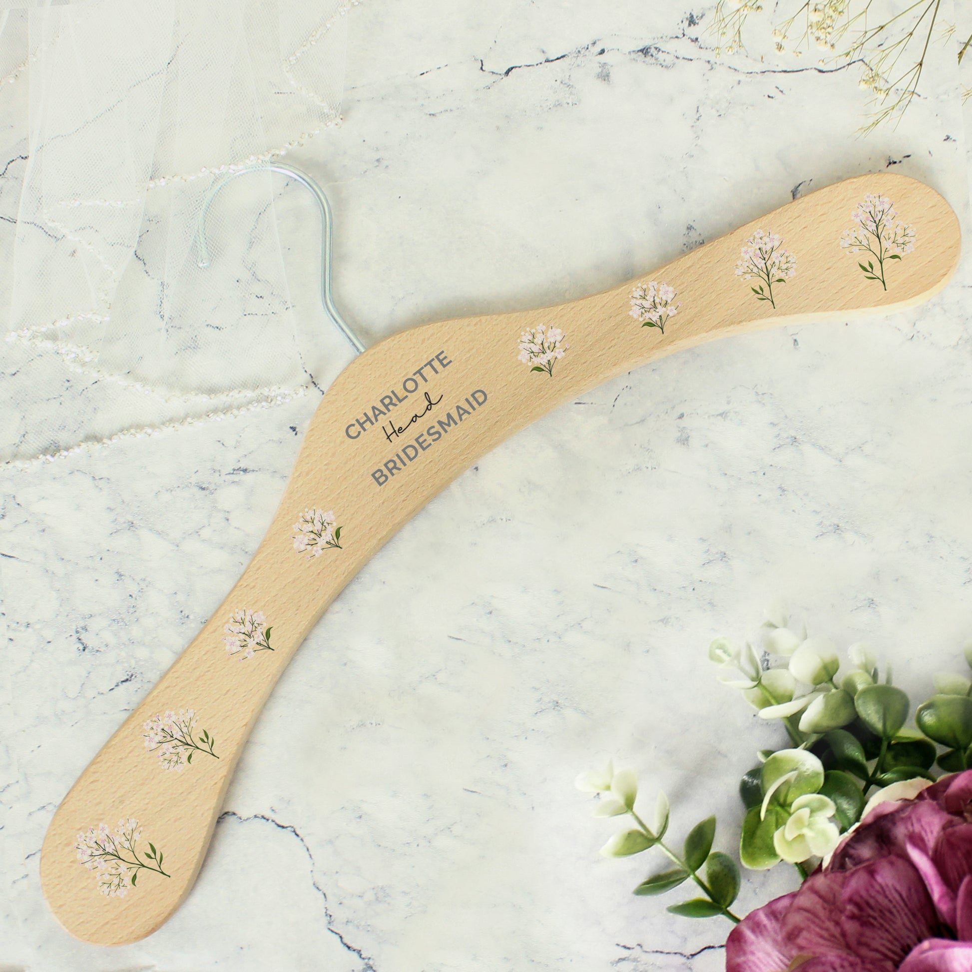 PERSONALISED wooden wedding hanger with three lines of text and flowers along the arms of the hanger