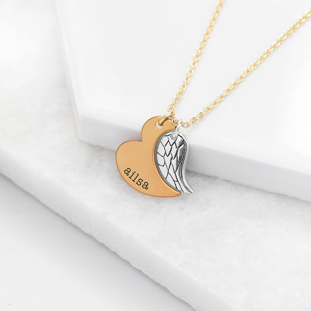 Silver plated angel wing charm is hung next to a partially formed gold plated heart. Together they complete the heart shape. gold part of heart can be engraved with a name of your choice.
