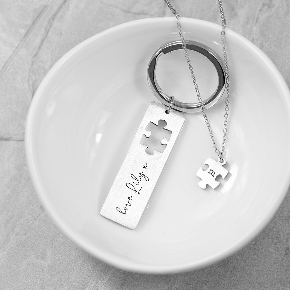 Perfect fit puzzle and keyring. The keyring has a missing jigsaw piece. The missing piece is on a pendant. Add a message to the keyring and an initial to the pendant.