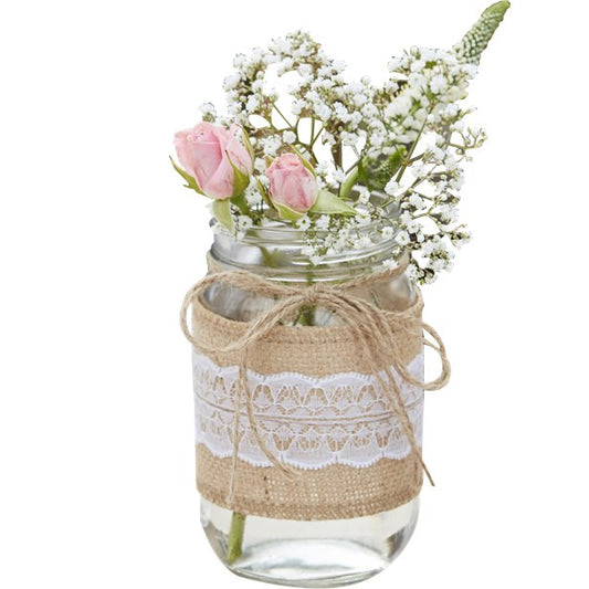 a jar wrapped in hessian and lace an filled with flowers, for a table centrepiece