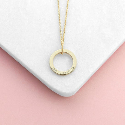 gold plated ring charm necklace engraved with initials and a special date, suspended from a rose gold chain