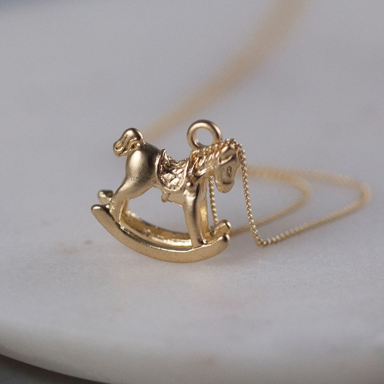 tiny gold plated rocking horse on an 18" gold plated chain