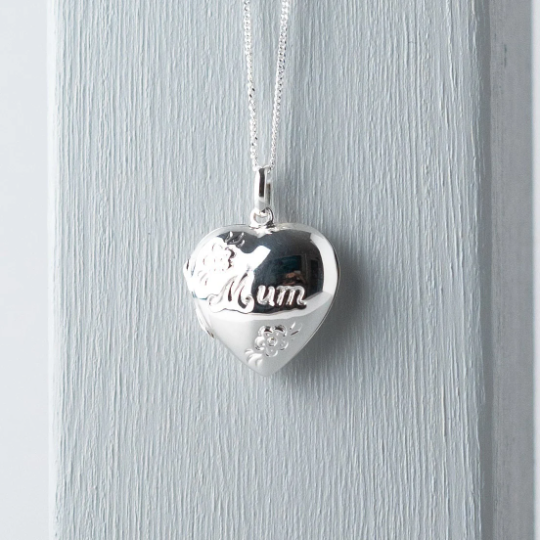 Sterling silver heart shaped locket engraved with the word "Mum" in script and flower decoration. Suspended from a sterling silver chain.