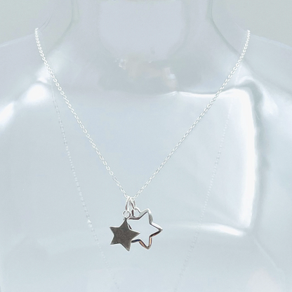 Two sterling silver stars, one solid, one outline hung from a sterling silver pendant and placed in a glass bottle. Part of the Message in a Bottle range. 