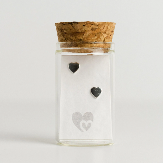 sterling silver heart stud earrings in a glass bottle. Comes with parchment scroll for you to write your own message.