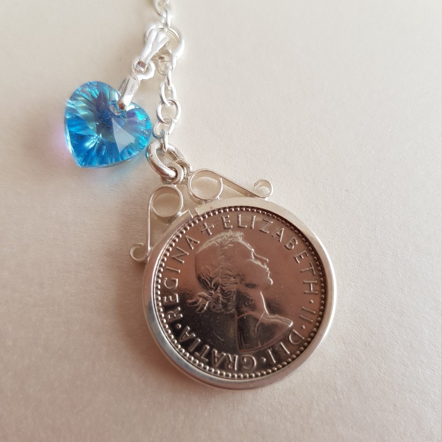 Close up of real British sixpence with blue crystal heart wedding bouquet charm
