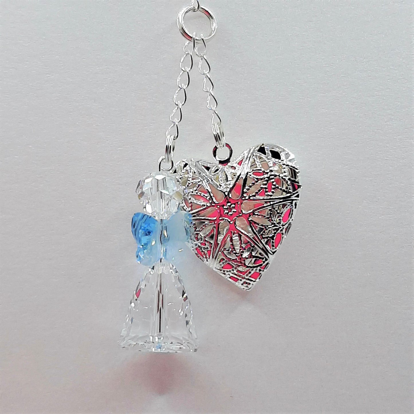 A crystal angel with blue wings and a filigree locket in a bouquet charm