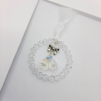 Crystal circle encasing two crystal wedding bells topped with a silver bow. Each bell has a tiny blue bead for Something Blue.