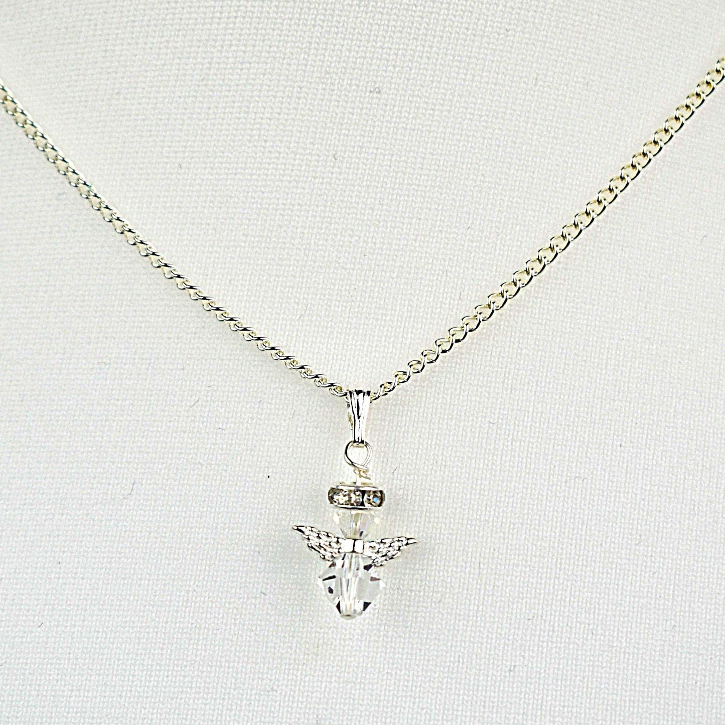 Snow angel Christmas pendant and earrings shown in clear and rose crystal. Necklace has an 18" silver plated chain while earrings are hung from sterling silver wires.