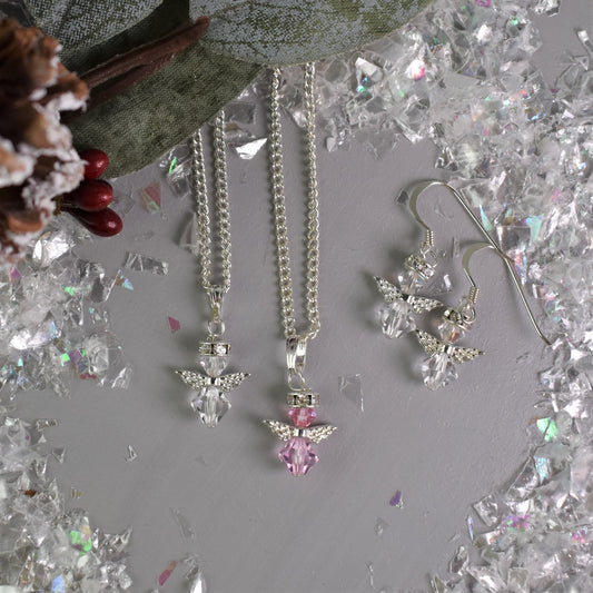 Anow angel Christmas pendant and earrings shown in clear and rose crystal. Necklace has an 18" silver plated chain while earrings are hung from sterling silver wires.