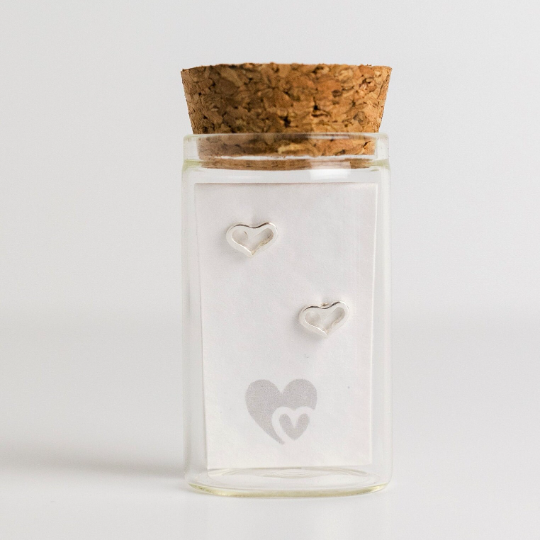 Heart outline stud earrings in sterling silver, in a glass bottle with cork lid, part of the Message in a bottle range