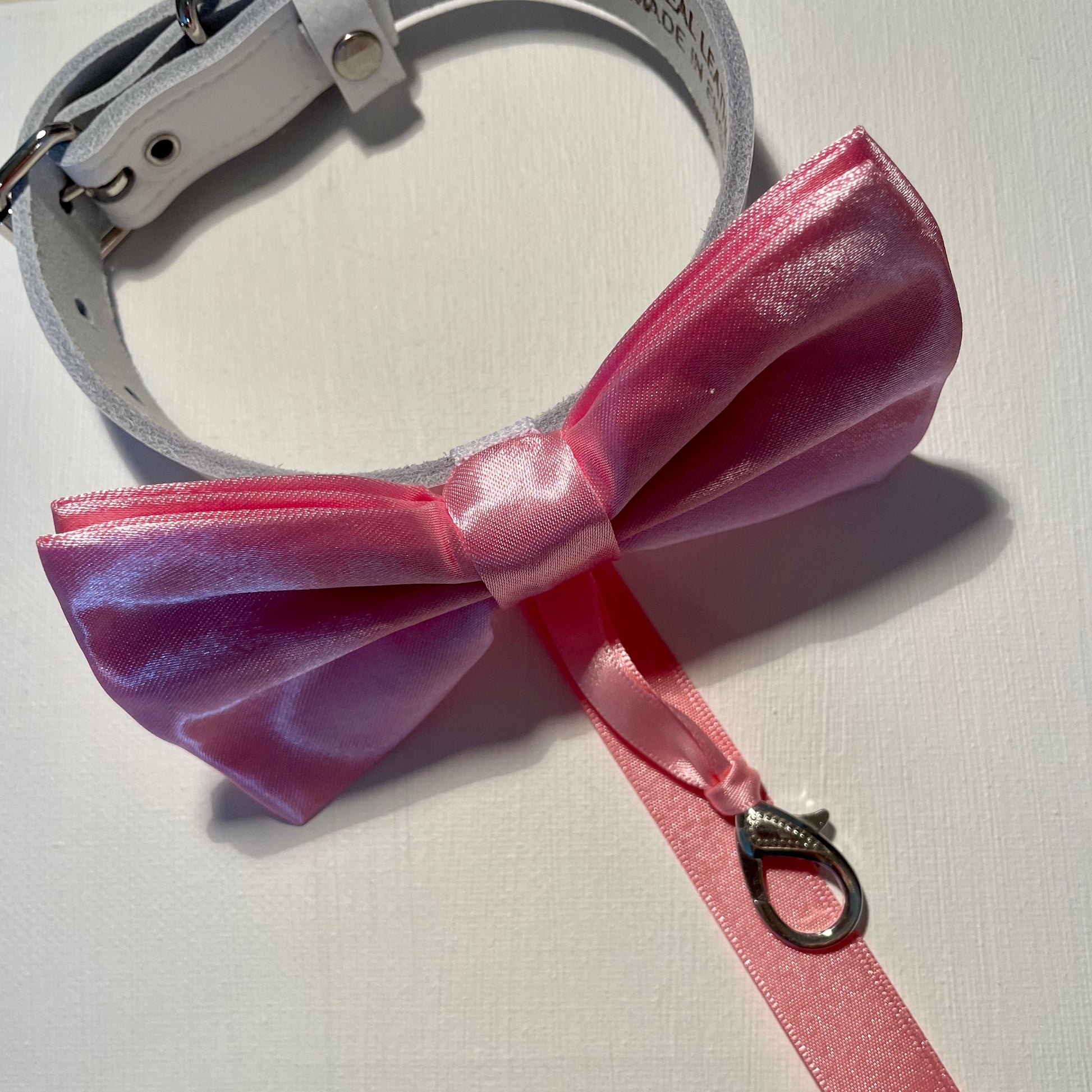 pink satin bow tie with optional ring carrier, secured to an adjustable white leather collar