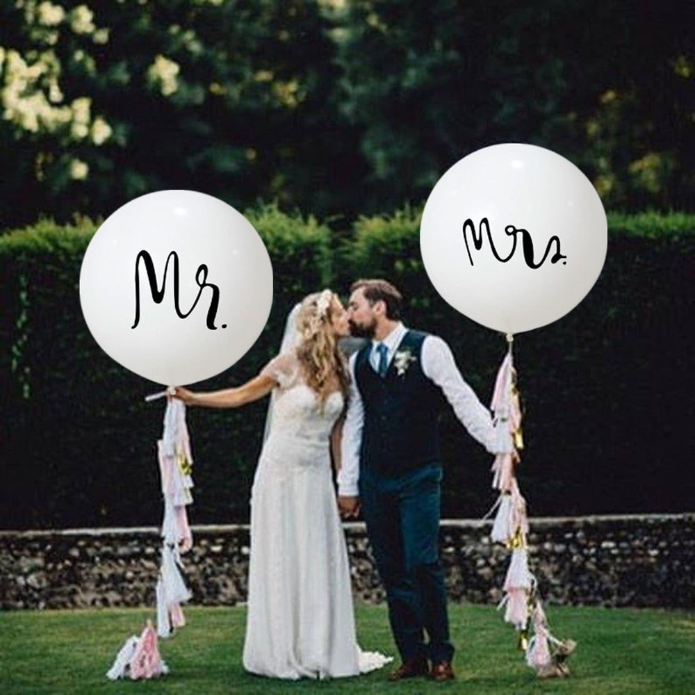 Couple holding giant Mr & Mrs Balloons