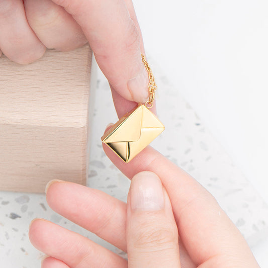 Tiny gold plated envelope hung from a gold plated chain