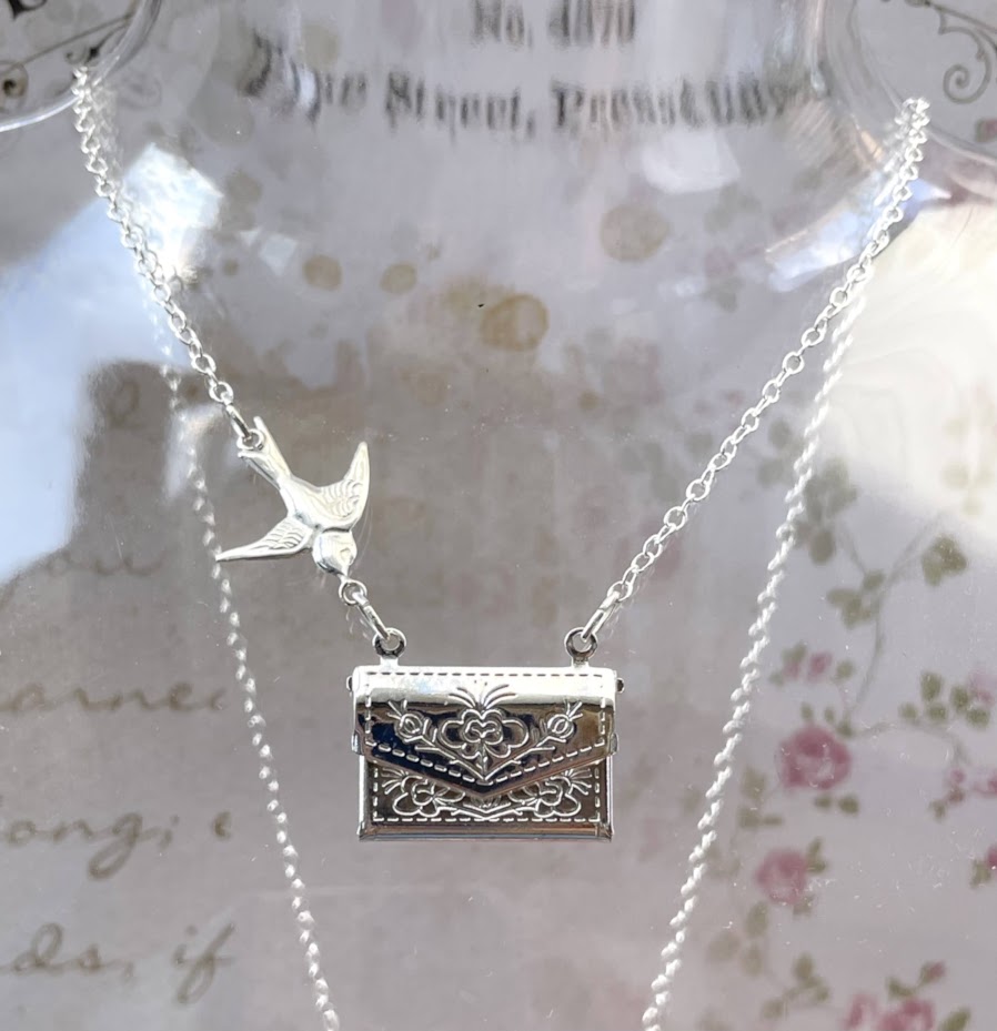 Sterling silver swallow flies towards a silver plated locket that opens to reveal the message of your choice. Secret message pendant.