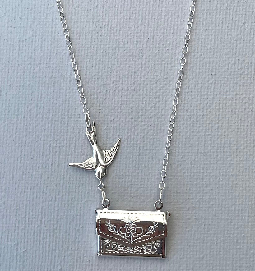 Sterling silver swallow flies towards a silver plated locket that opens to reveal the message of your choice. Secret message pendant.